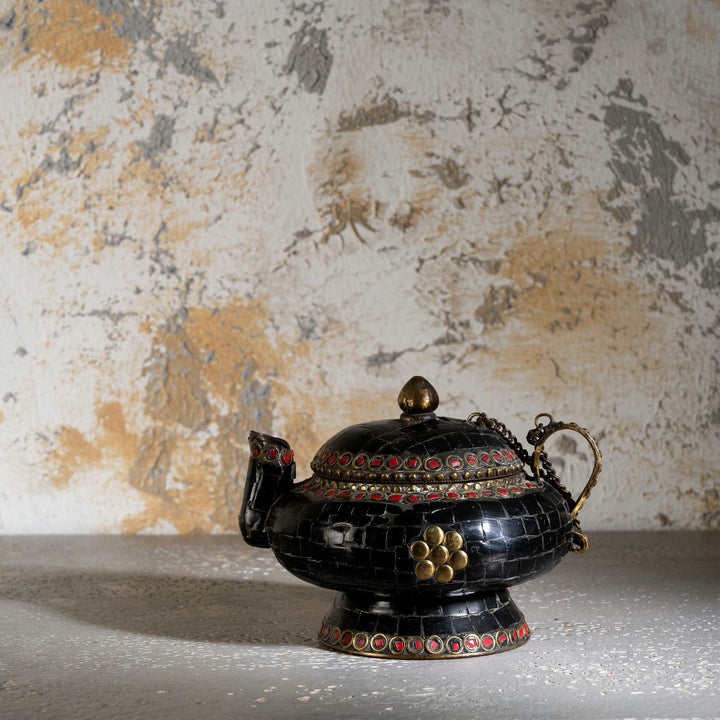 Black Stone Inlay Brass Teapot accented with ruby-red details on a dark walnut sideboard. 
