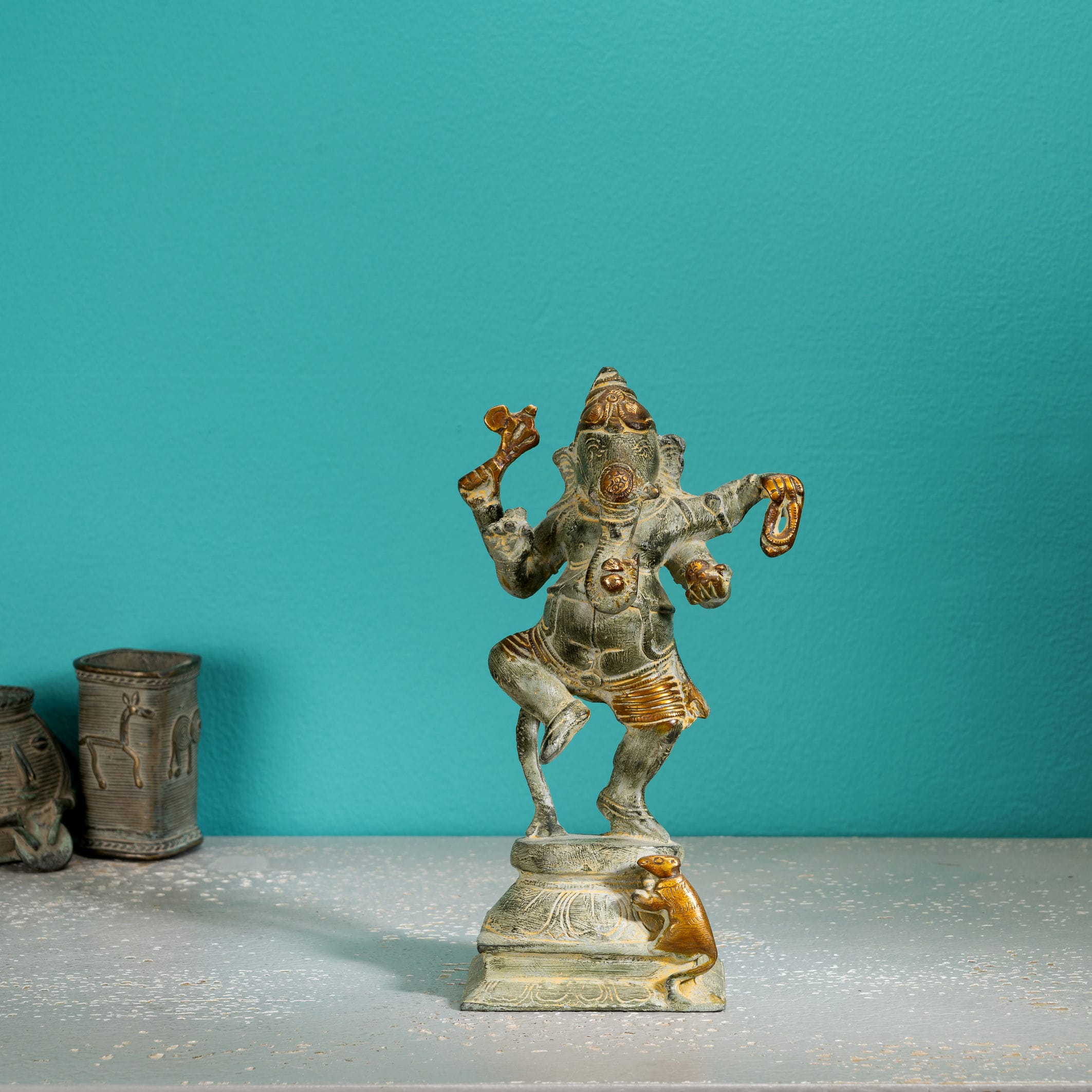 Verdigris Brass Dancing Ganesha Statue balancing effortlessly on a prominent entryway console. 