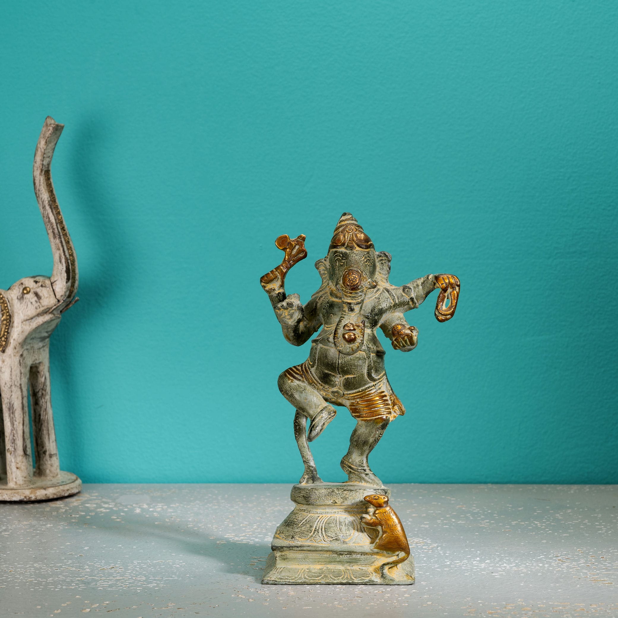 Verdigris Brass Dancing Ganesha Statue balancing effortlessly on a prominent entryway console. 