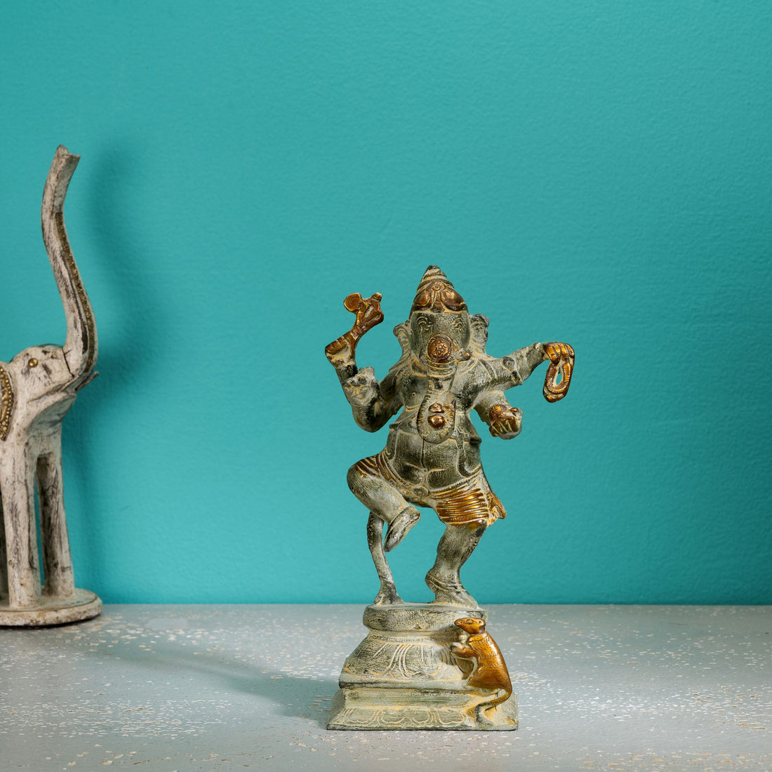 Verdigris Brass Dancing Ganesha Statue balancing effortlessly on a prominent entryway console. 