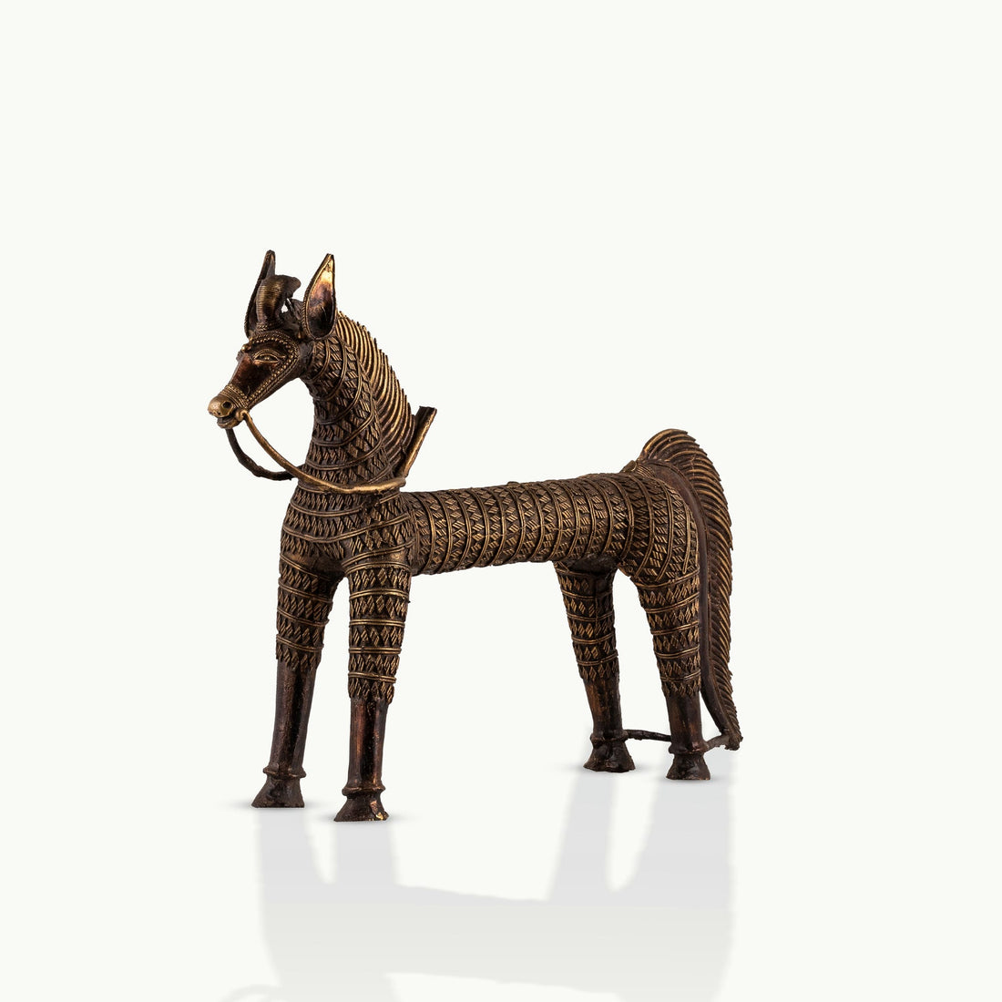 Monumental Antique Brass Horse Sculpture standing rigidly on a reclaimed wood console. 