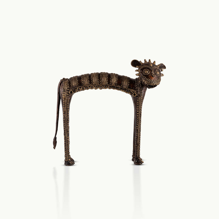 Dhokra Brass Tribal Feline Sculpture staring fiercely on a minimalist concrete credenza. 