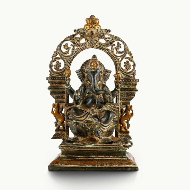 Dual-tone brass Ganesha statue with an arch, seated upon a lotus base.