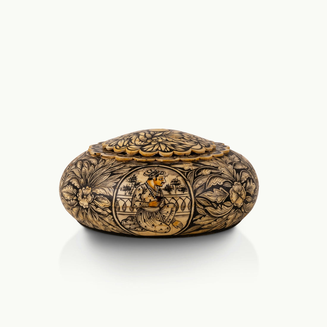 Black etched camel bone box showing carved Rajput court musicians on a dark oak dressing table. 