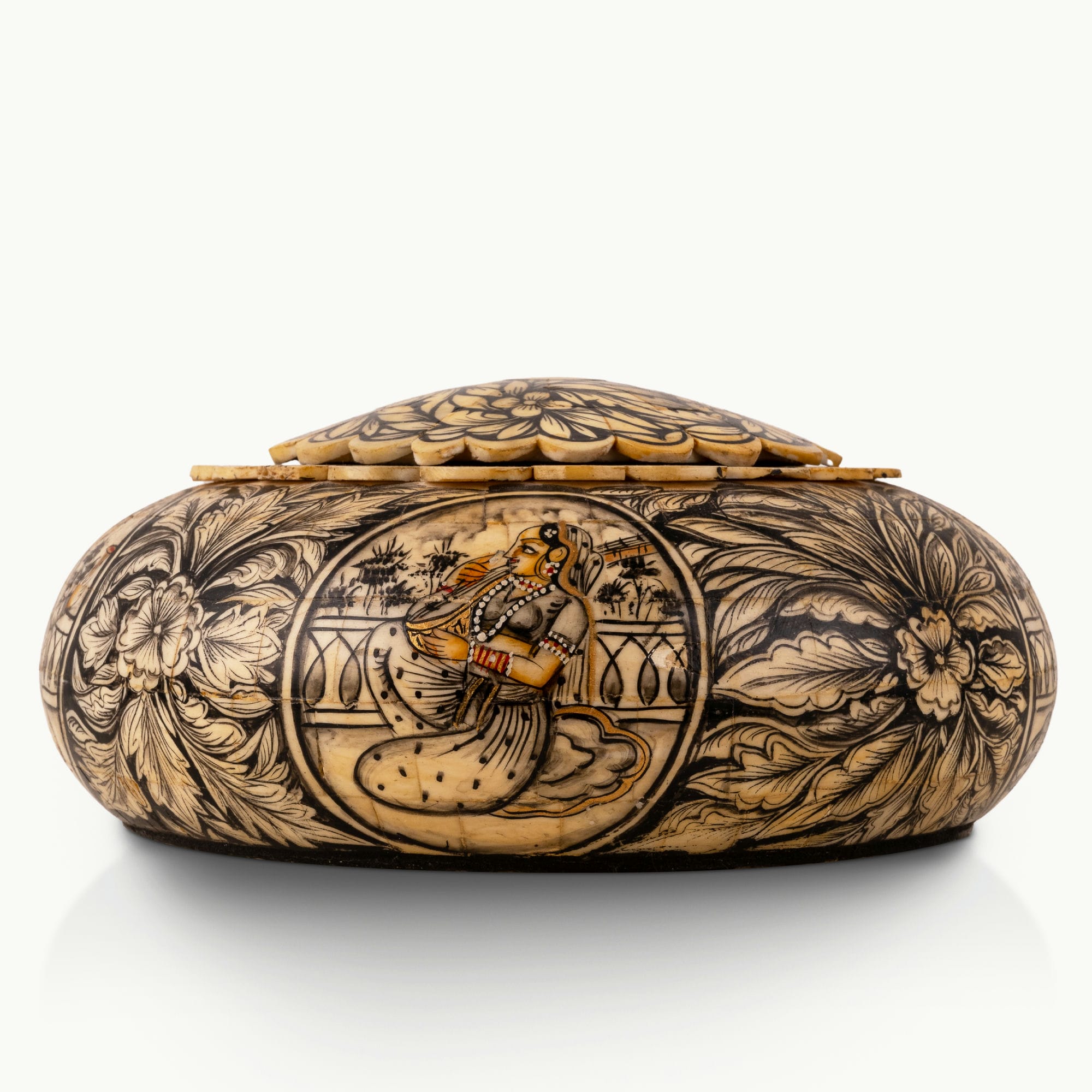 Black etched camel bone box showing carved Rajput court musicians on a dark oak dressing table. 