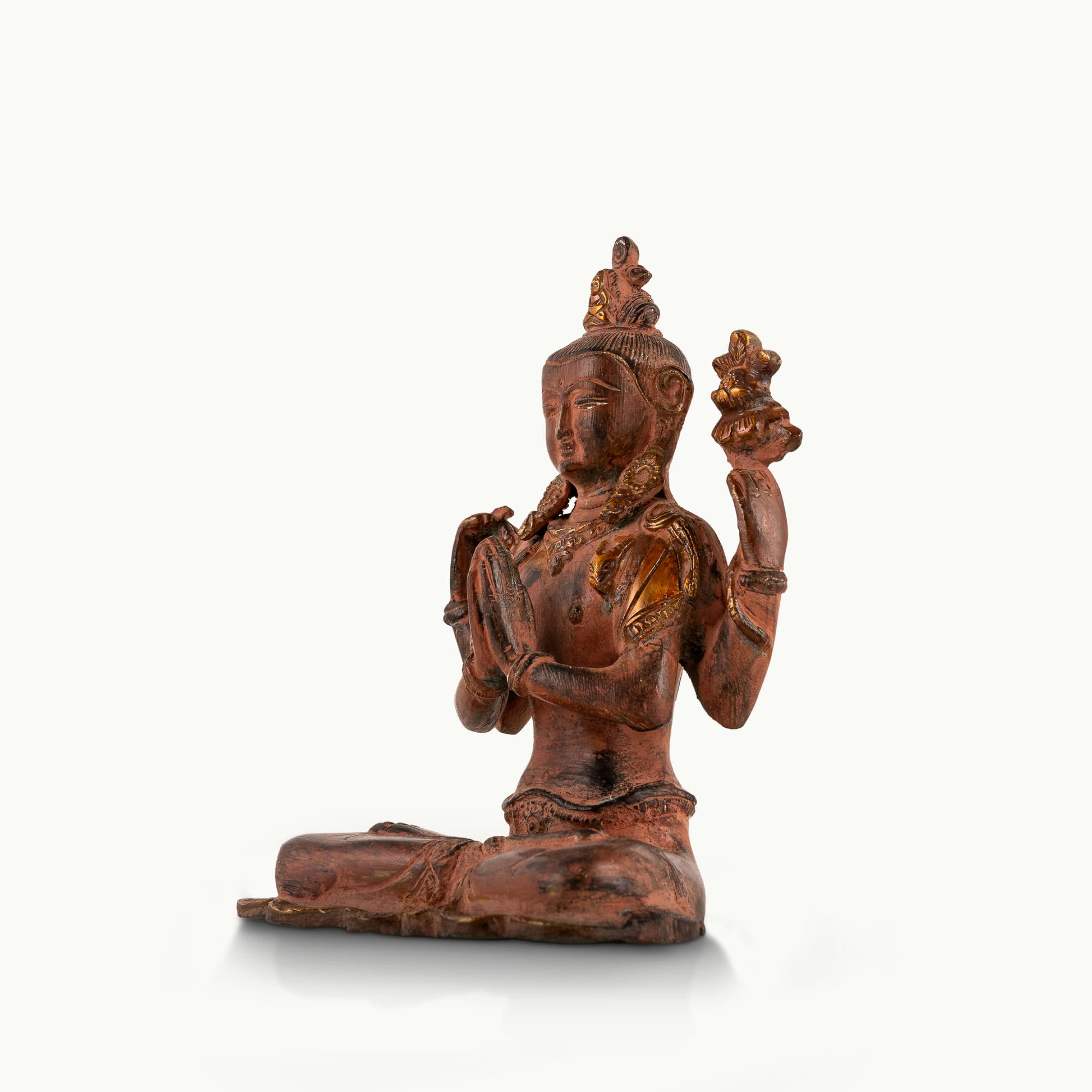 Red Oxidized Brass Tara Statue showing four arms of compassion on an east-facing meditation altar. 