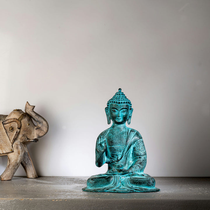 Hand-engraved Tibetan meditation idol with a striking teal patina for a living room mantle or Vastu alignment.