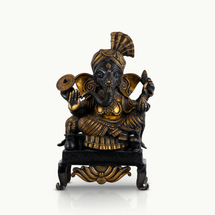 Black brass seated Ganesha statue featuring a polished golden turban and dark patinated body.