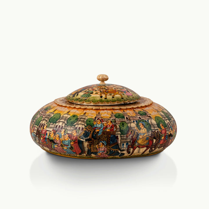 Painted round camel bone box featuring a vibrant royal procession scene bathed in a golden-amber wash.