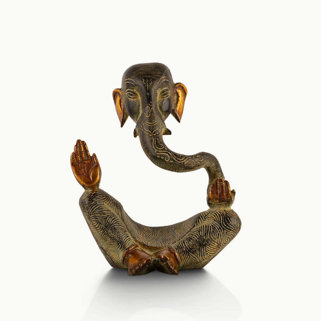 Abstract Brass Ganesha Sculpture displaying a floating torso on a light-wood console. 