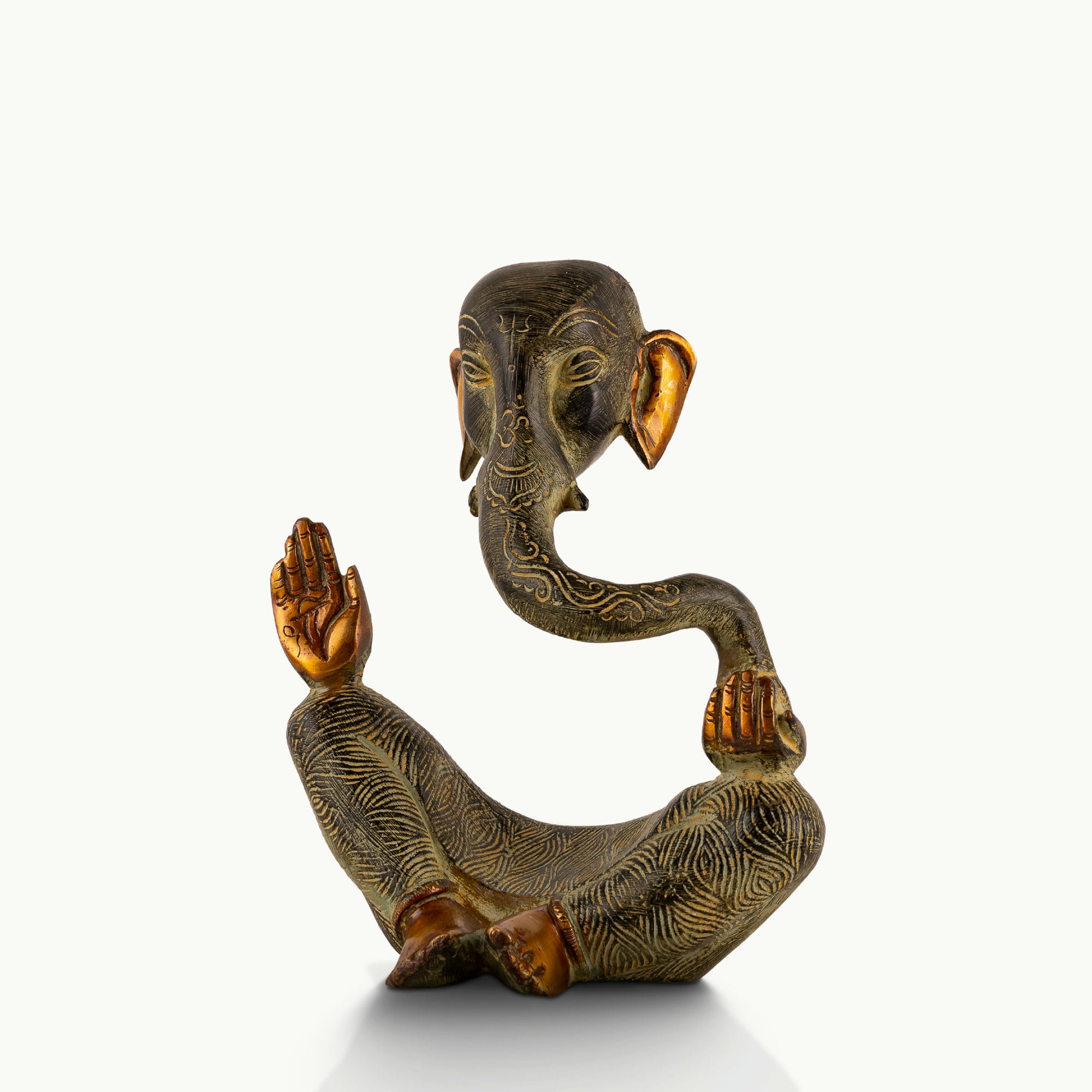 Abstract Brass Ganesha Sculpture displaying a floating torso on a light-wood console. 