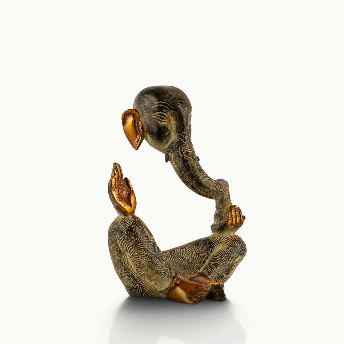 Abstract Brass Ganesha Sculpture displaying a floating torso on a light-wood console. 