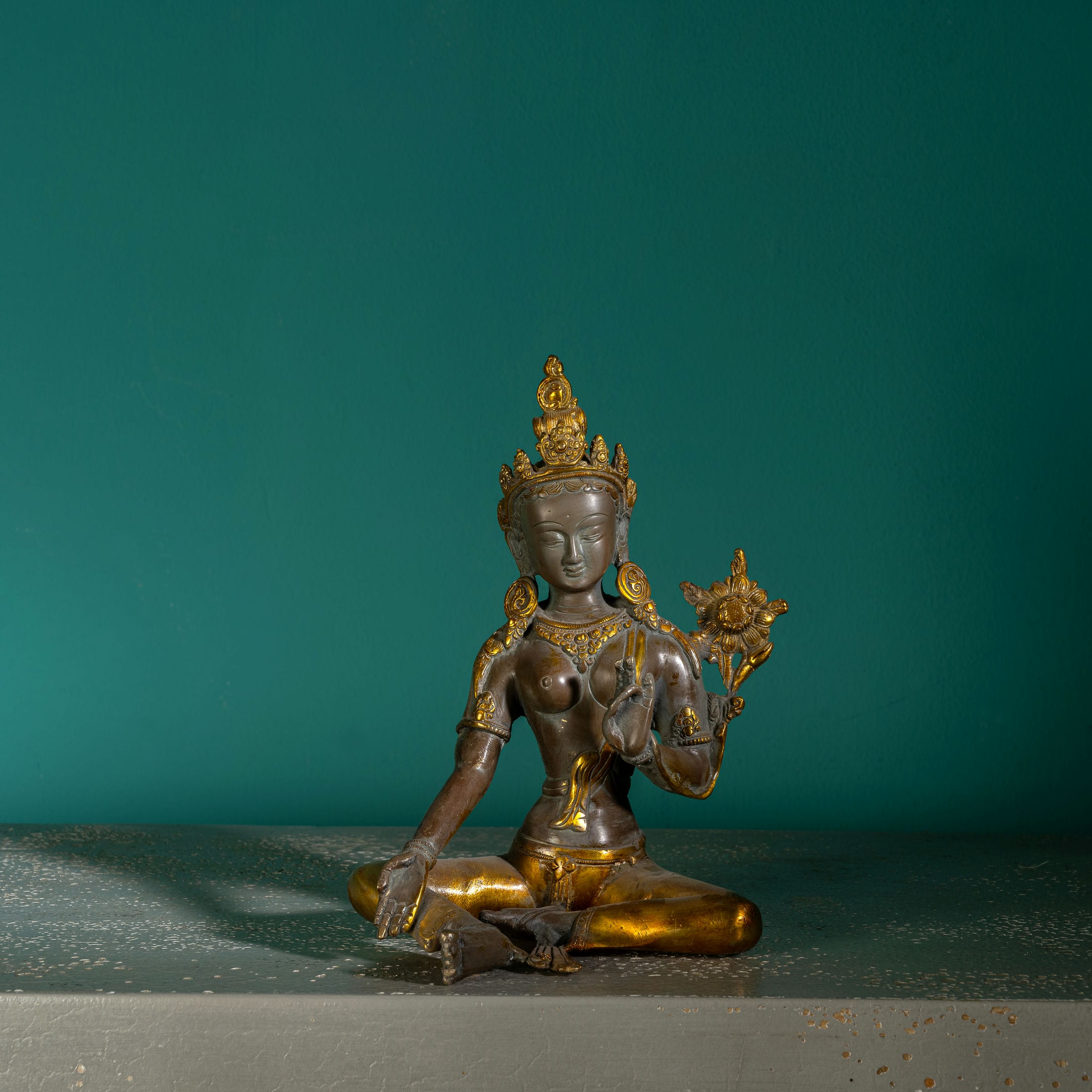 Antique gilded bronze seated bodhisattva with lotus blossom