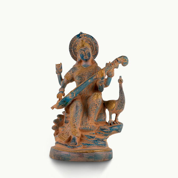Dual-Tone Brass Saraswati Statue cradling a veena gracefully on a dedicated library console. 