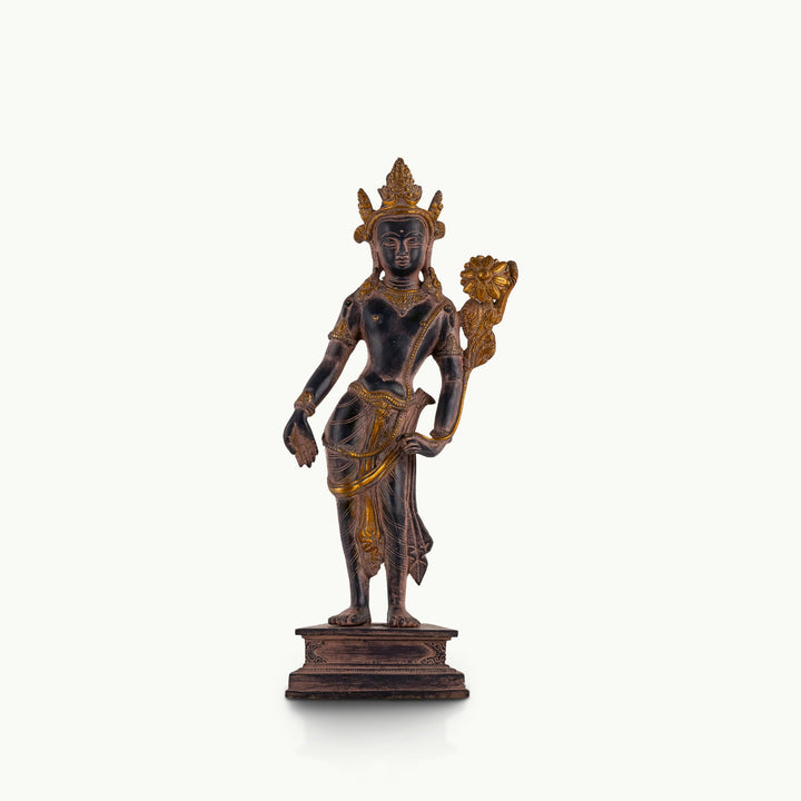 Dual-Tone Brass Padmapani Statue holding a blooming lotus stem on a minimalist entryway console. 