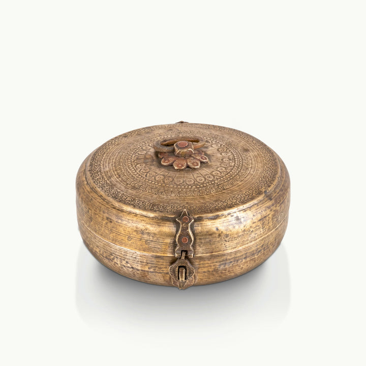 Engraved brass circular box featuring a deep hammered patina and a central floral handle.