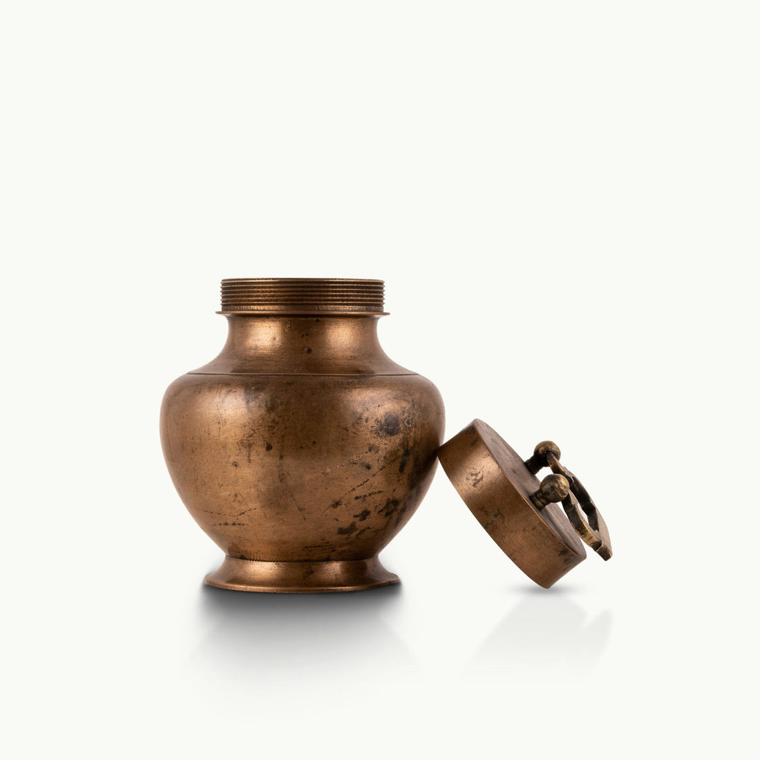 Antique Brass Locking Urn equipped with a dual-pin lid for a rustic reclaimed wood console.