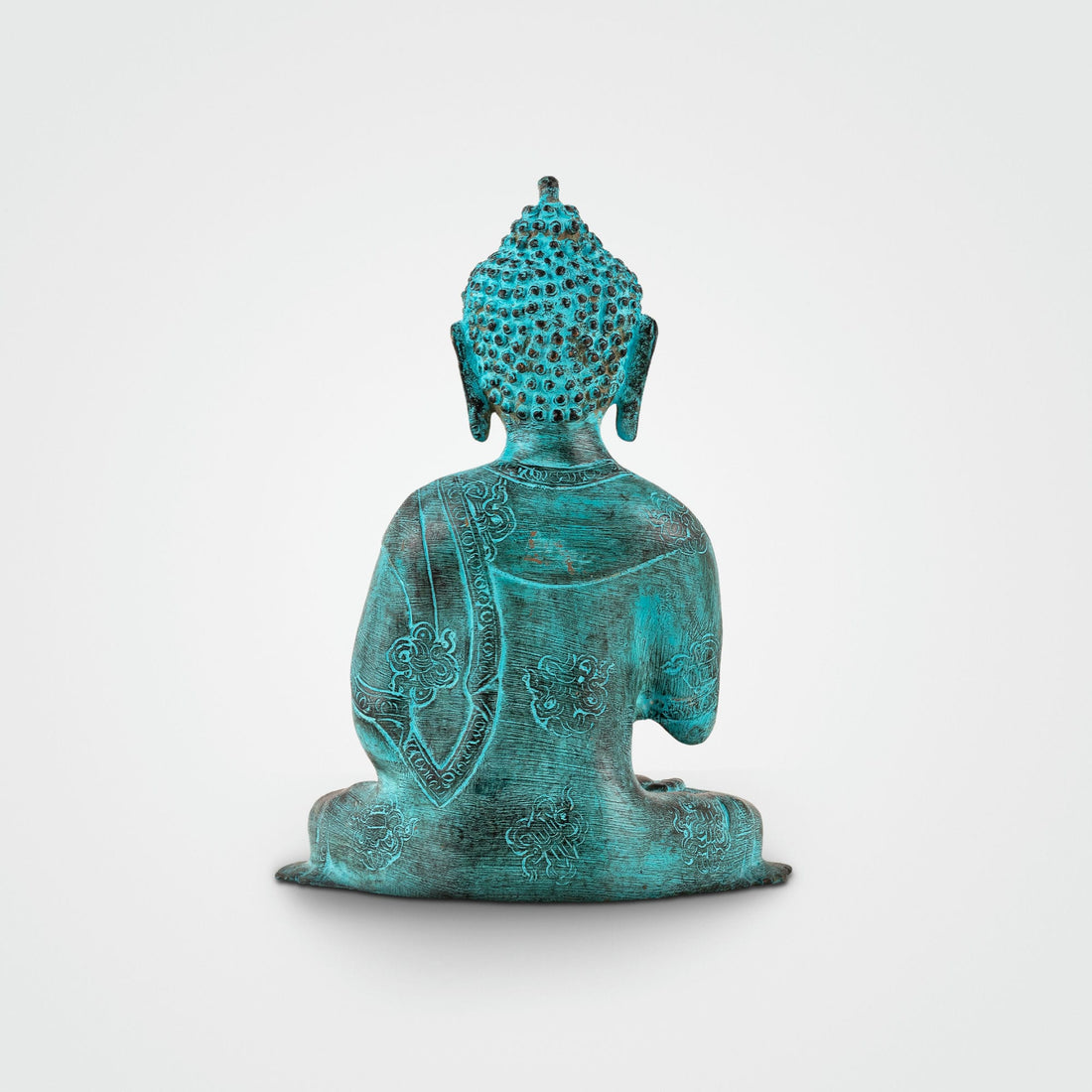 Hand-engraved Tibetan meditation idol with a striking teal patina for a living room mantle or Vastu alignment.