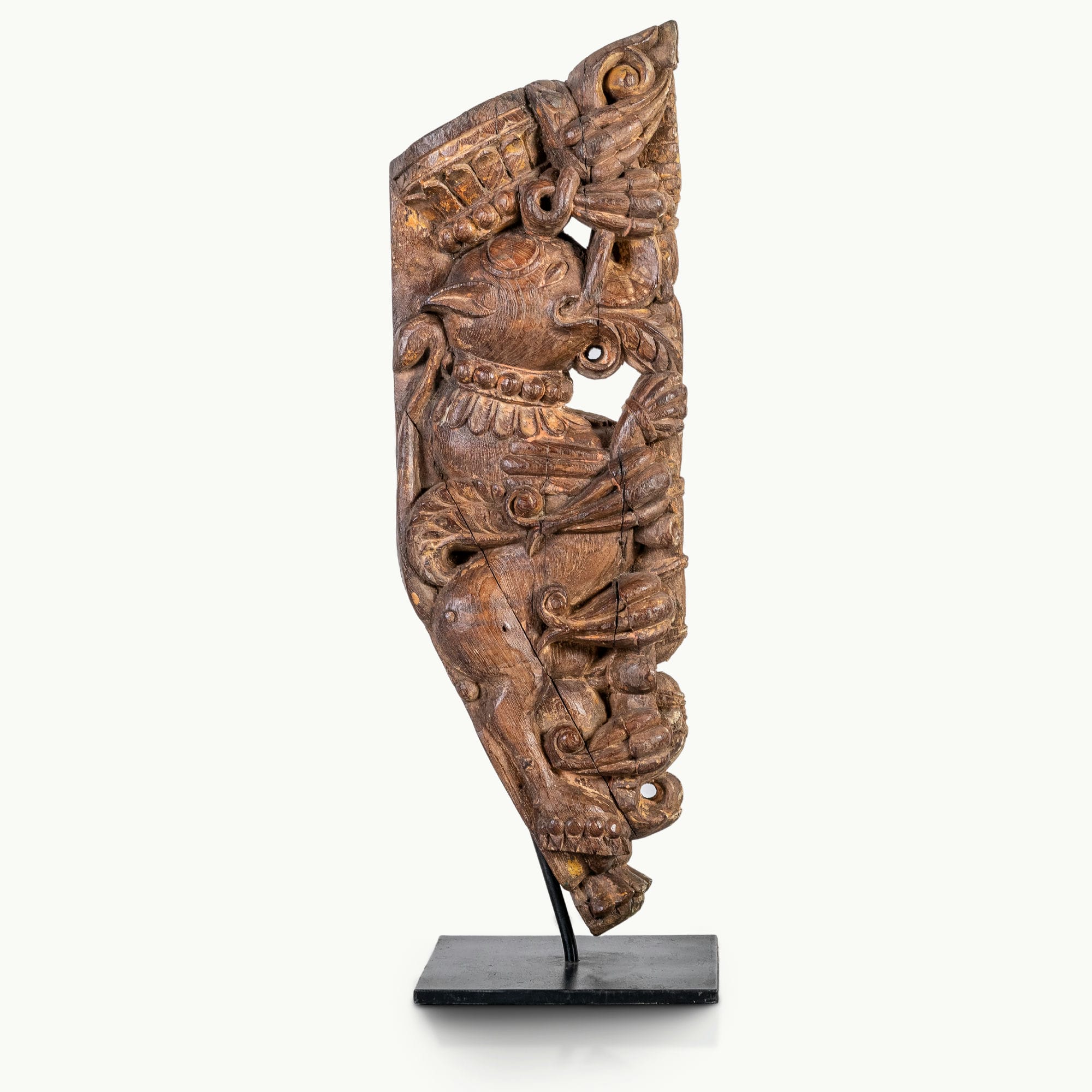 Carved wooden haveli bracket featuring a mythological avian sentinel.