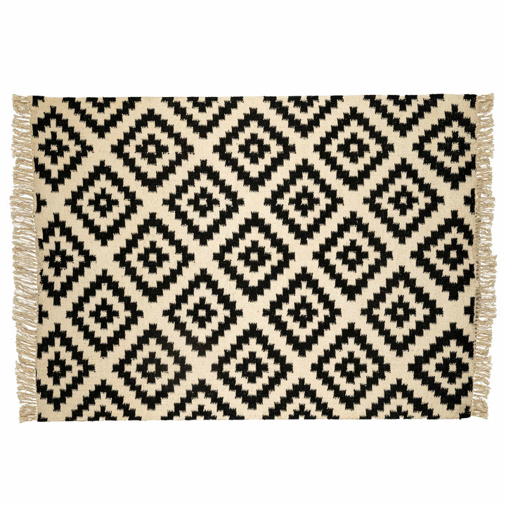 Tribal chevron cotton wool dhurrie in a living room, displaying stepped rust and sage green chevrons. 