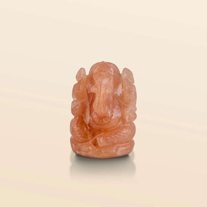 Carved onyx stone Ganesha statue with a warm peach glow and semi-precious stone detailing.