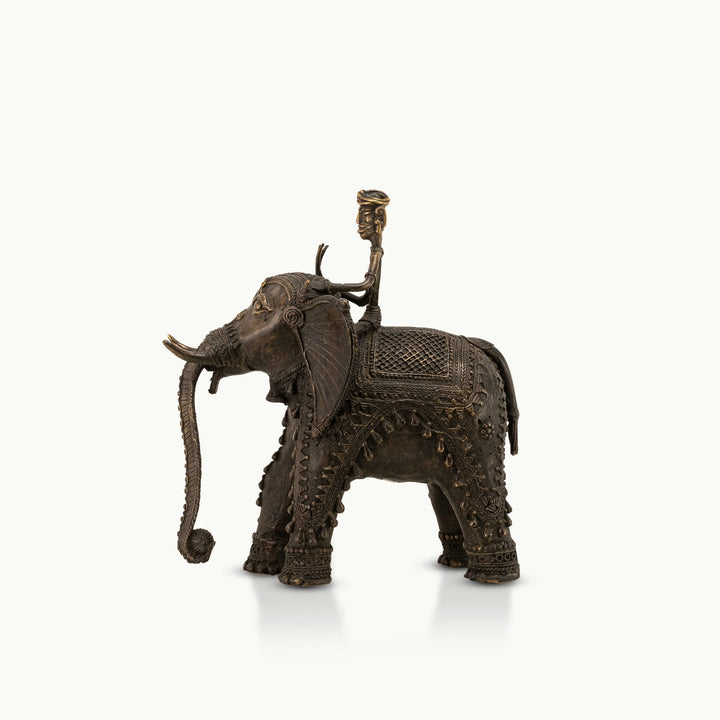 Dhokra Brass Elephant Rider Statue capturing ceremonial progress on a rustic wooden console. 