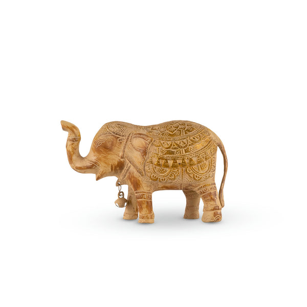 Whitewashed brass elephant sculpture with a raised trunk and gold painted ceremonial saddle.