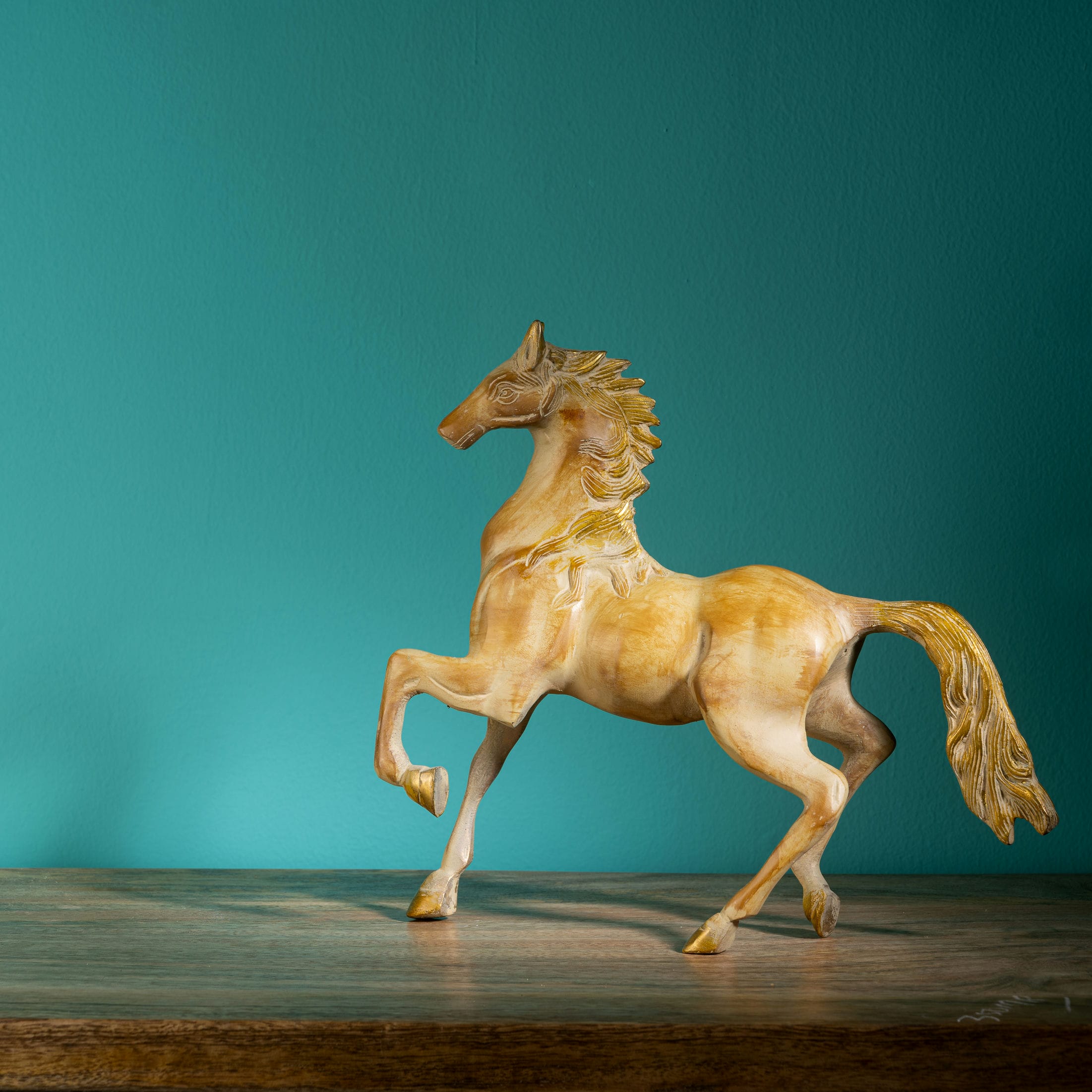 Antique resin-cast stylized horse figurine with gilded mane and tail