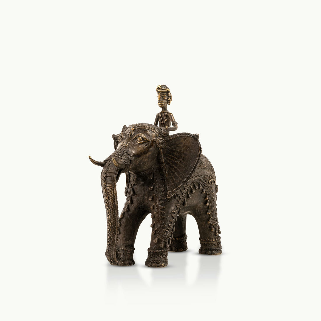 Dhokra Brass Elephant Rider Statue capturing ceremonial progress on a rustic wooden console. 