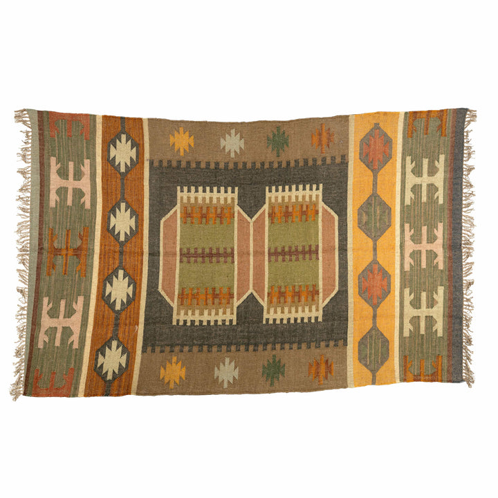 Panja flatweave wool jute kilim in a living room, featuring a serrated olive green and beige mosaic. 