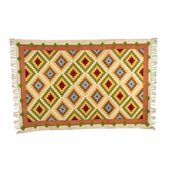 Concentric diamond cotton wool dhurrie in a living room, highlighting expanding yellow and sage ripples. 