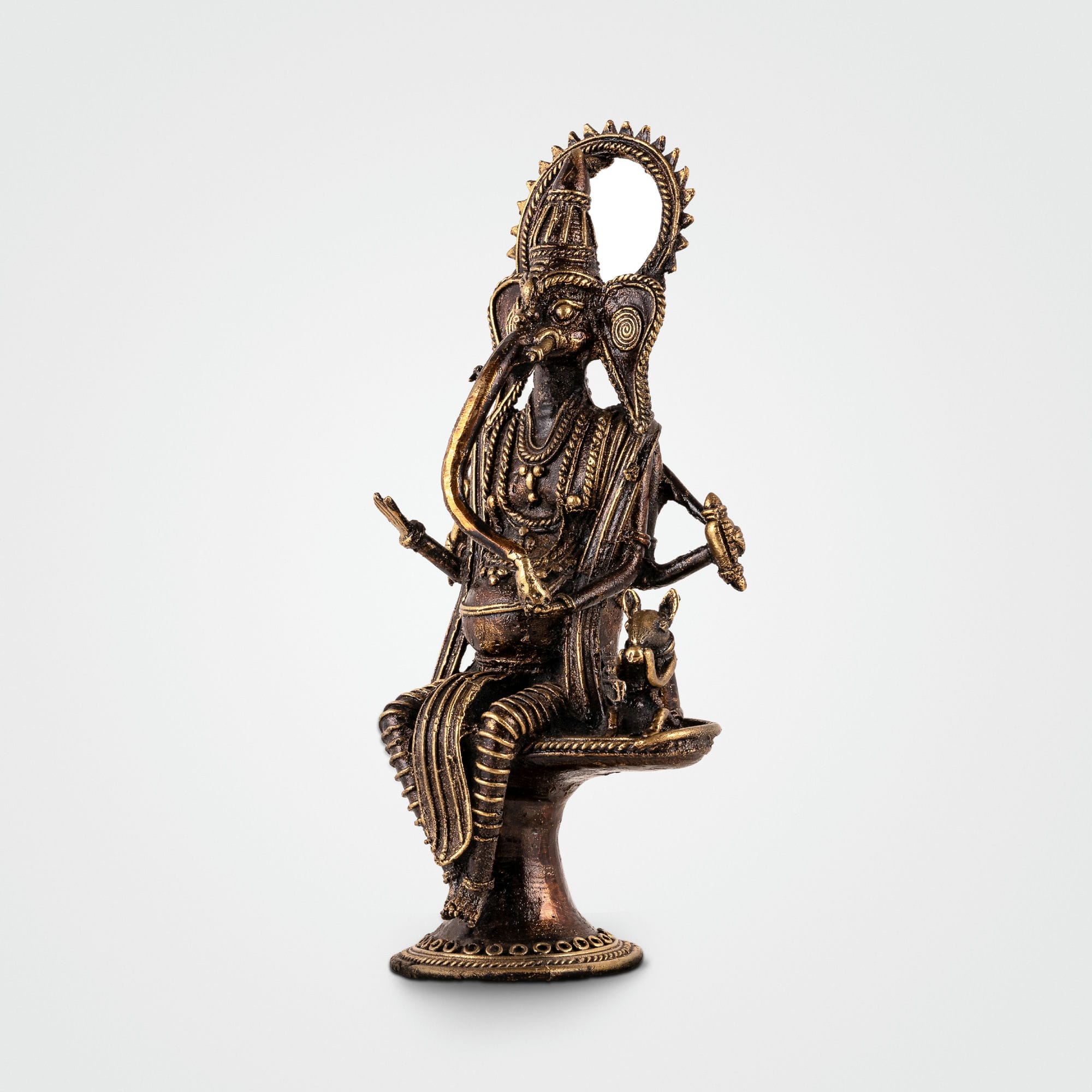 Four-armed Ganpati decor accompanied by Mooshak the mouse on a pedestal for an illuminated living room alcove or festive Diwali decor.