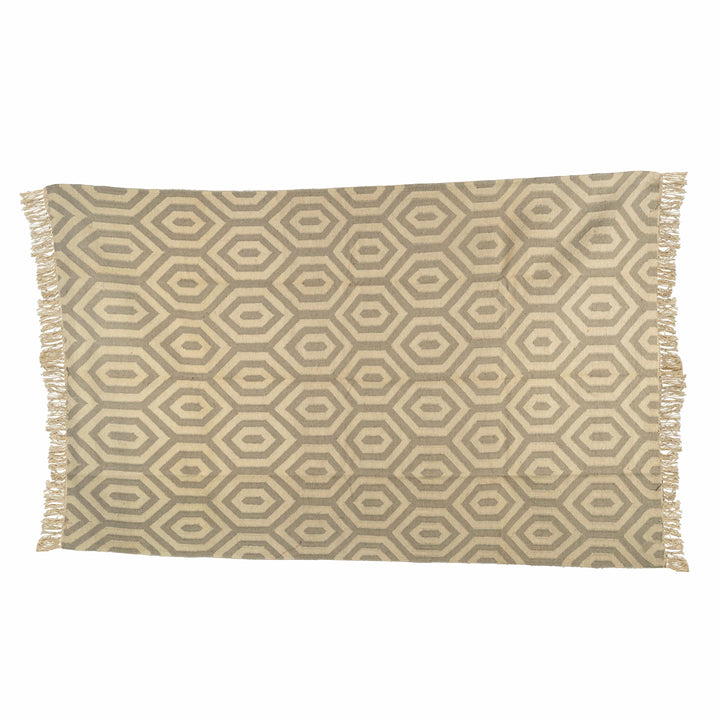 Hexagon cotton wool dhurrie in a bedroom, displaying a rhythmic taupe-brown and stone-grey honeycomb. 