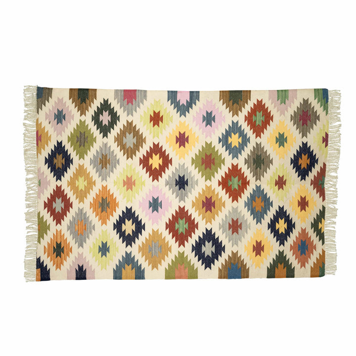 Handwoven geometric cotton dhurrie in a living room, showcasing vibrant multicolour stepped diamonds. 