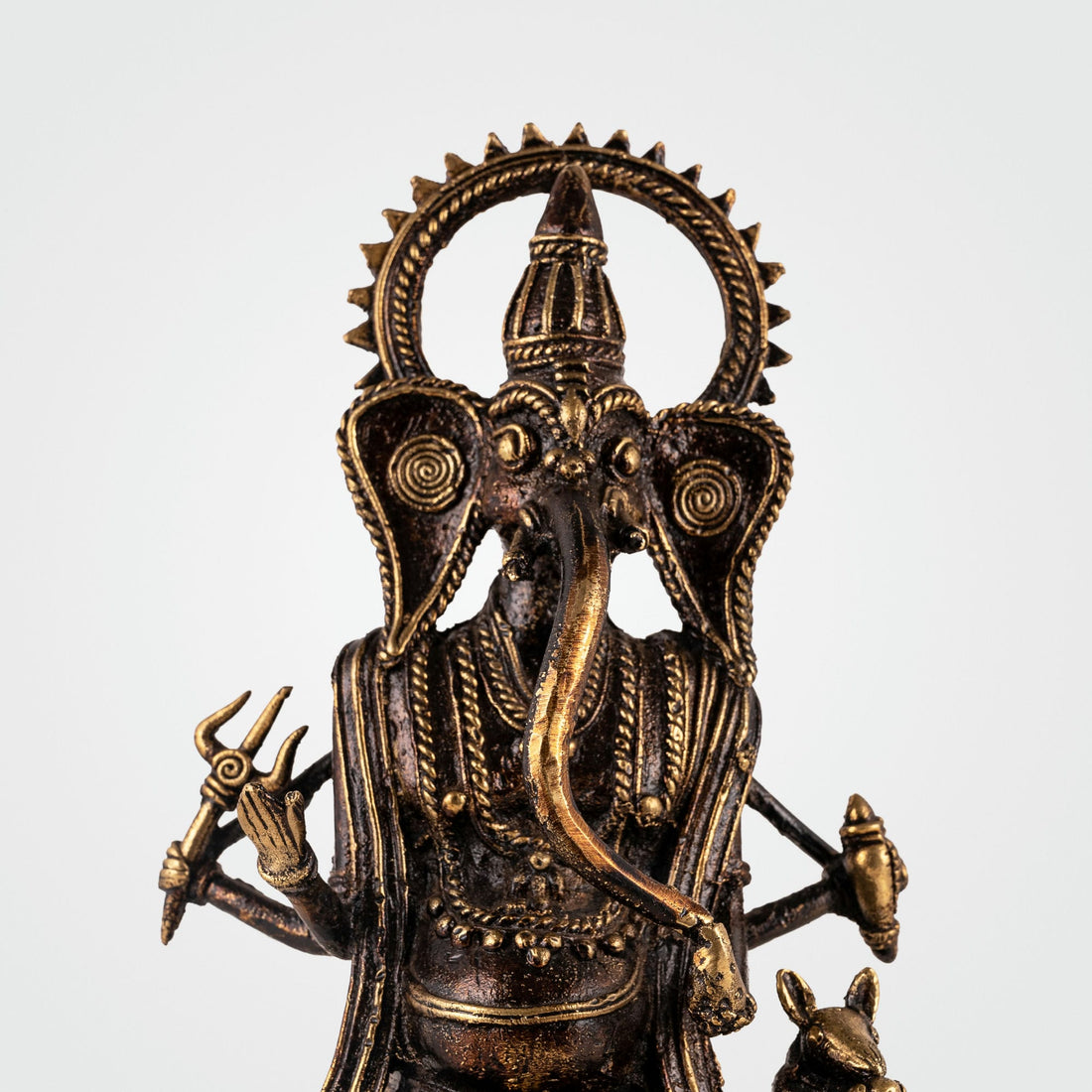 Four-armed Ganpati decor accompanied by Mooshak the mouse on a pedestal for an illuminated living room alcove or festive Diwali decor.