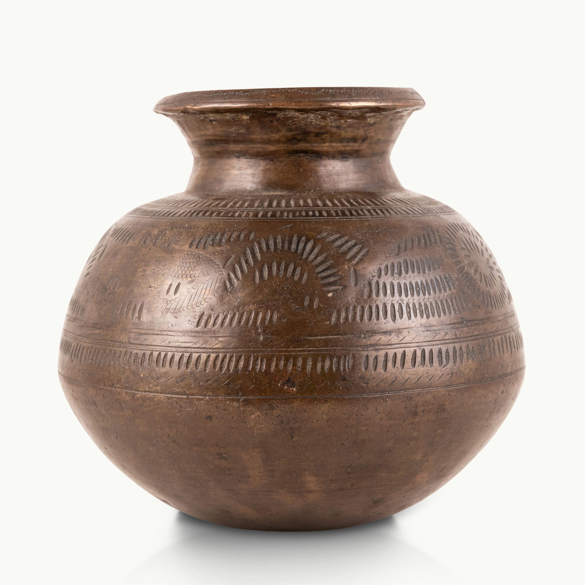 Stamped Antique Brass Water Pot covered in rhythmic dashes for a raw concrete console.
