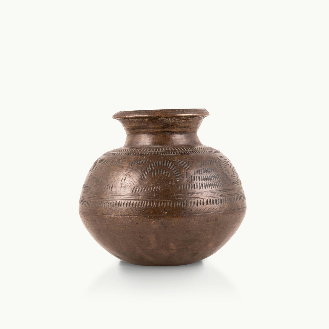 Stamped Antique Brass Water Pot covered in rhythmic dashes for a raw concrete console.