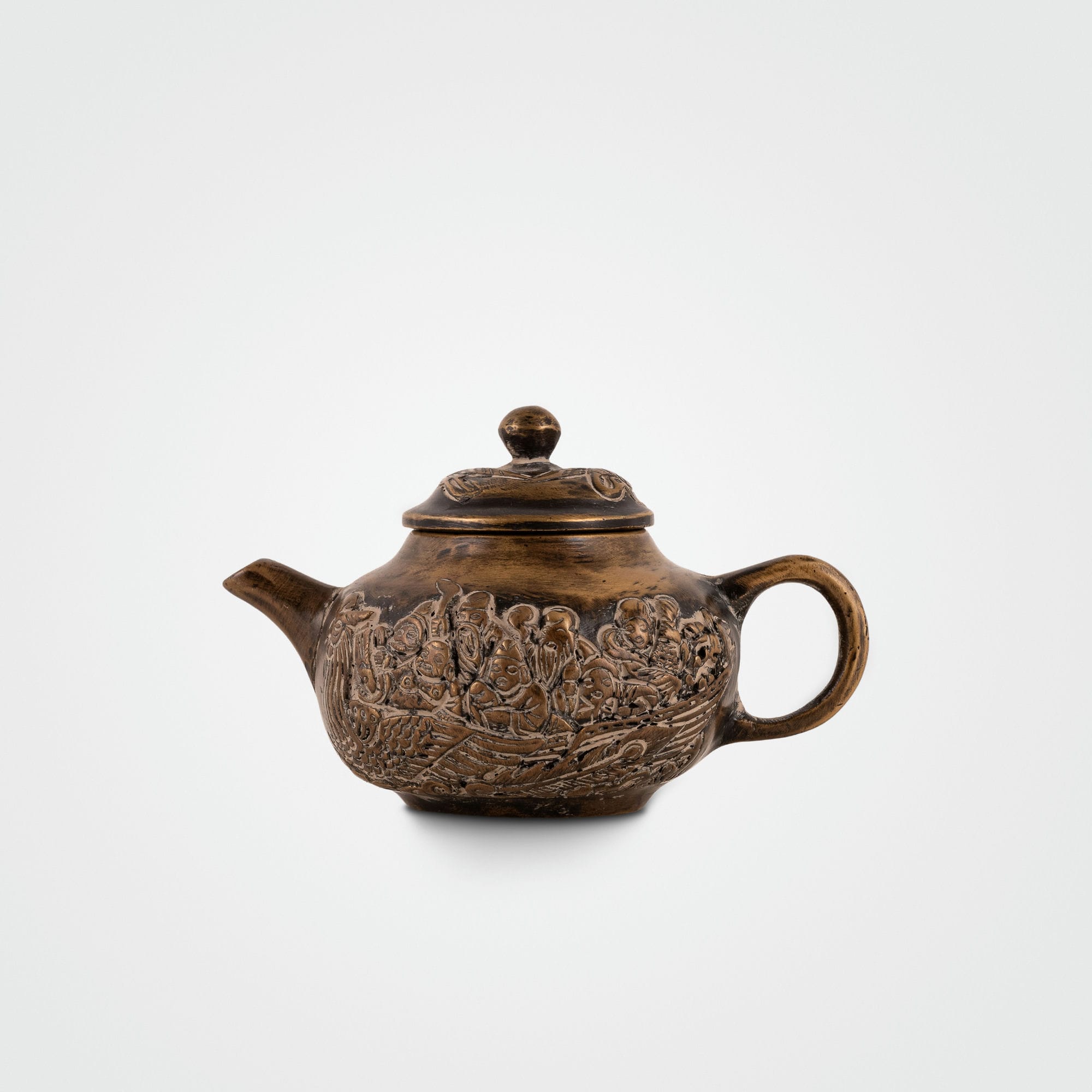 Brass Mythological Teapot depicting a maritime narrative on an open wooden bookshelf. 