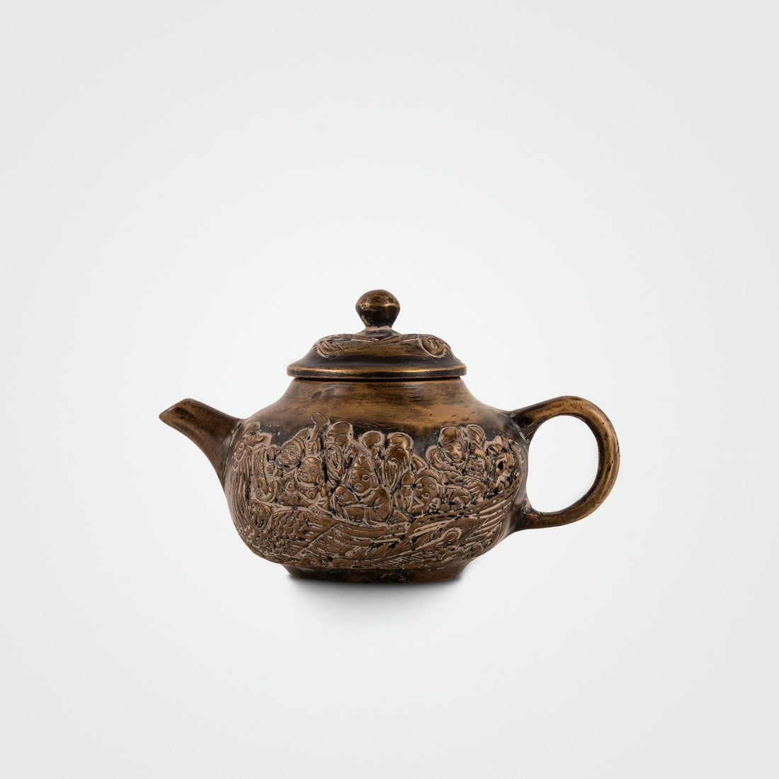 Brass Mythological Teapot depicting a maritime narrative on an open wooden bookshelf. 