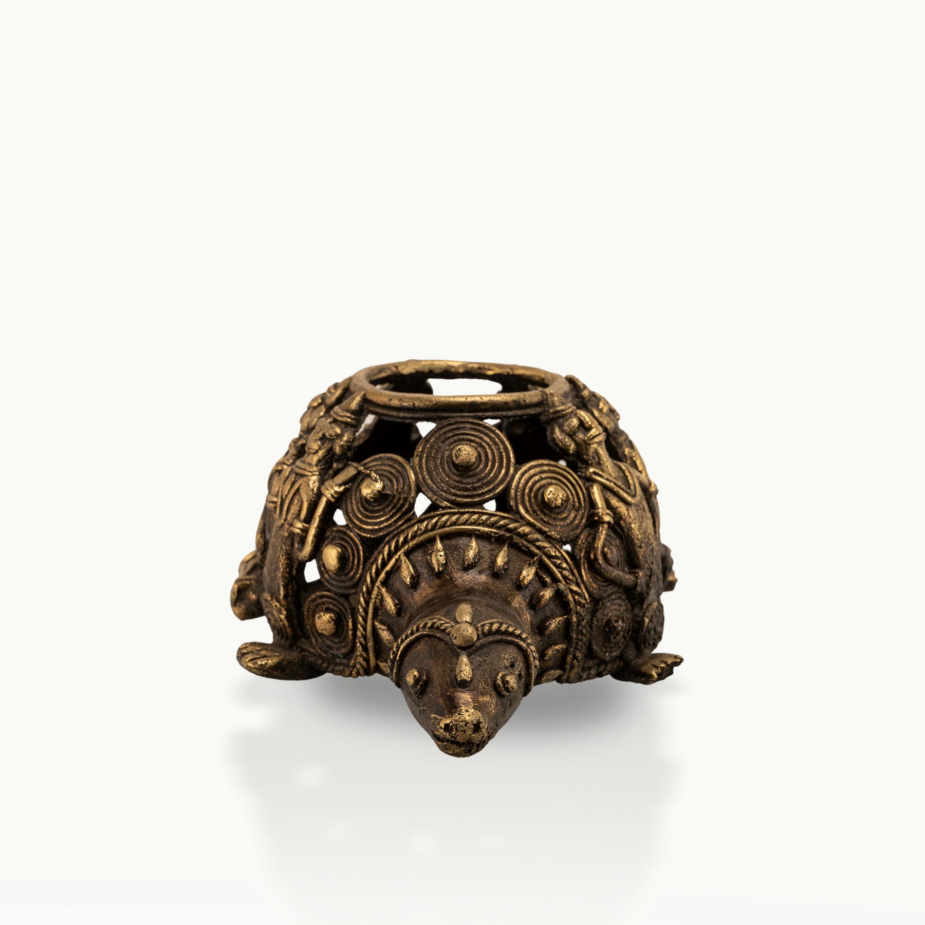 Dhokra Brass Tortoise Tealight Holder casting shadows on a sheltered patio bench. 