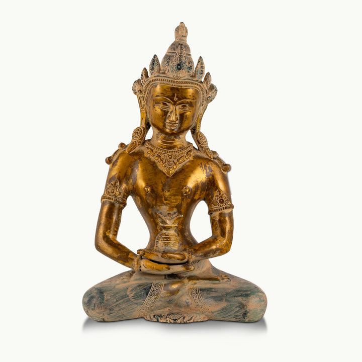 Distressed Brass Tara Statue holding the Amrita Kalasha on a home altar. 