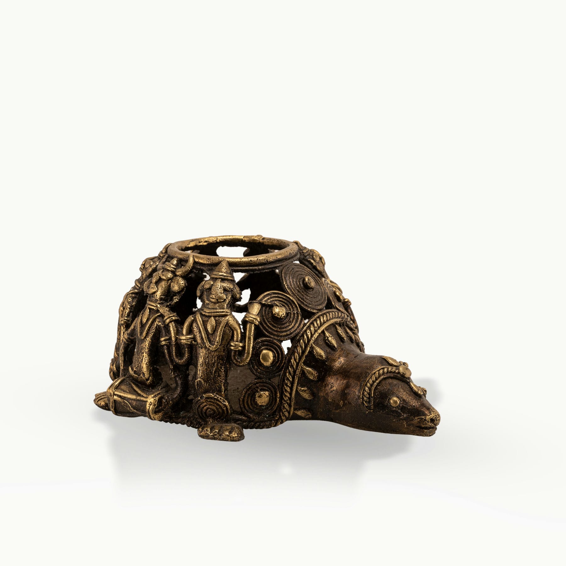 Dhokra Brass Tortoise Tealight Holder casting shadows on a sheltered patio bench. 