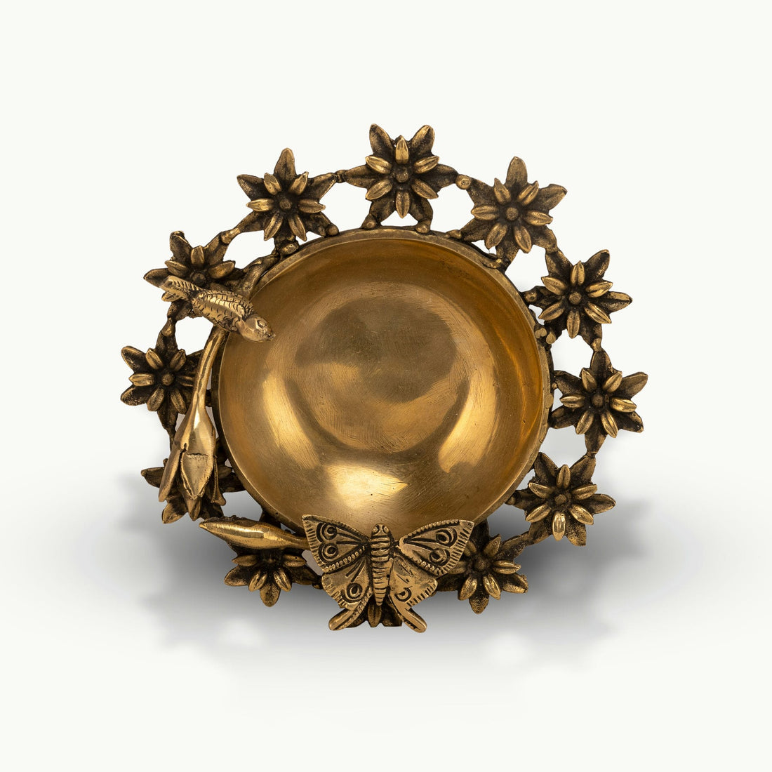 Antique Brass Floral Decorative Bowl framed by sculpted wildlife on an entryway table. 