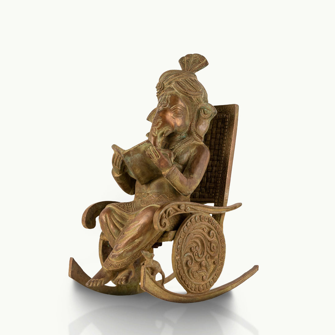 Antique Brass Rocking Chair Ganesha engrossed in a manuscript for a mahogany desk.