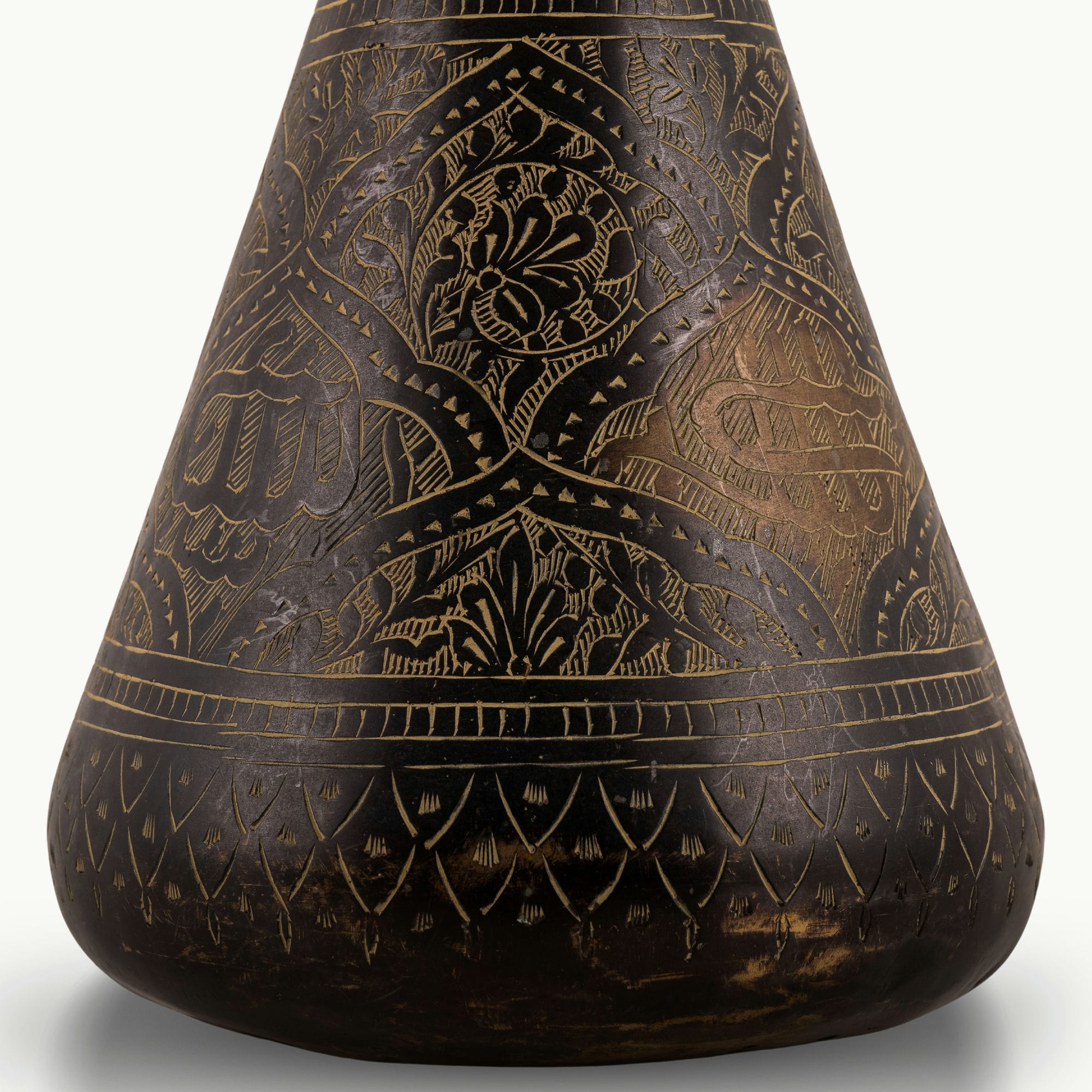 Engraved Brass Decorative Vase showcasing intricate stonework motifs on a neutral room console. 