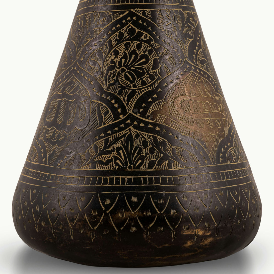 Engraved Brass Decorative Vase showcasing intricate stonework motifs on a neutral room console. 