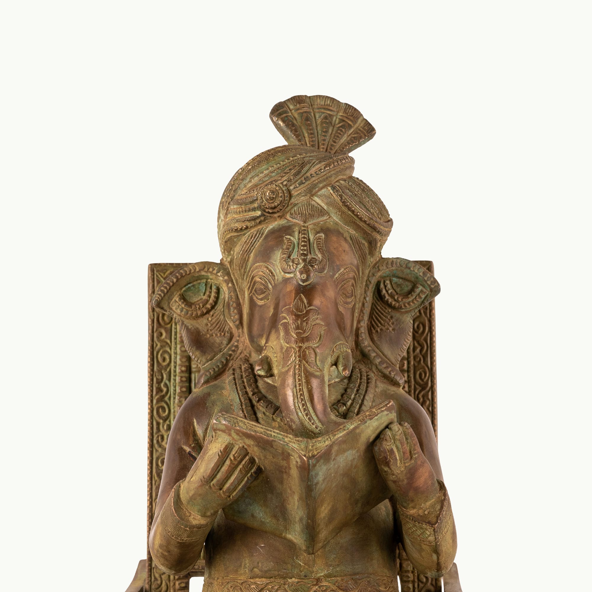 Antique Brass Rocking Chair Ganesha engrossed in a manuscript for a mahogany desk.