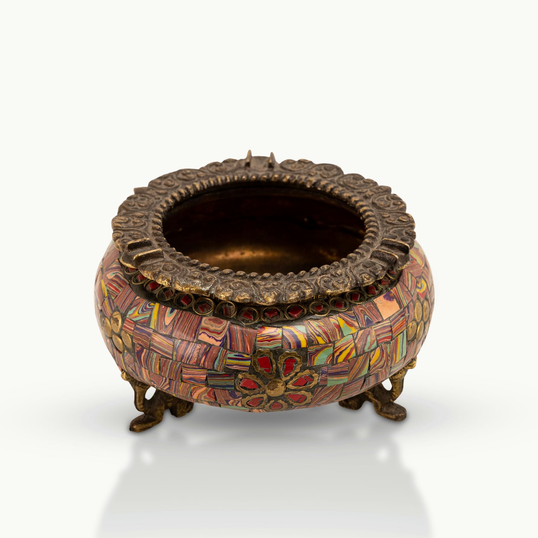 Brass Elephant Foot Mosaic Ashtray decorated with vibrant stones on a dark wood coffee table. 