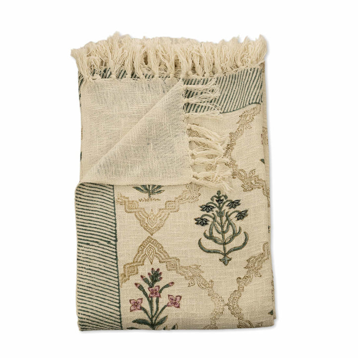 Fringed floral block-print bedcover for a master suite with a sage green border and hand-tied tassels.
