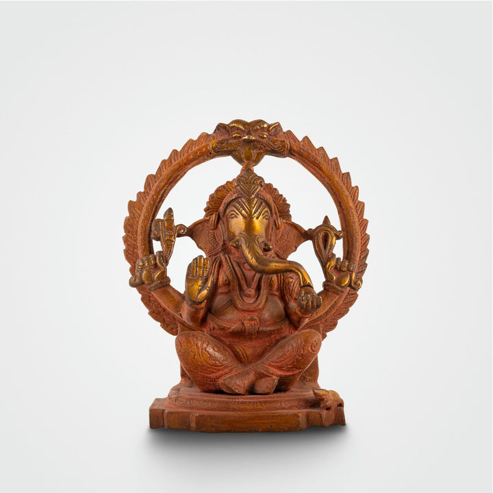 Red Oxidised Brass Ganesha Statue framed by a swirling halo on a home altar. 